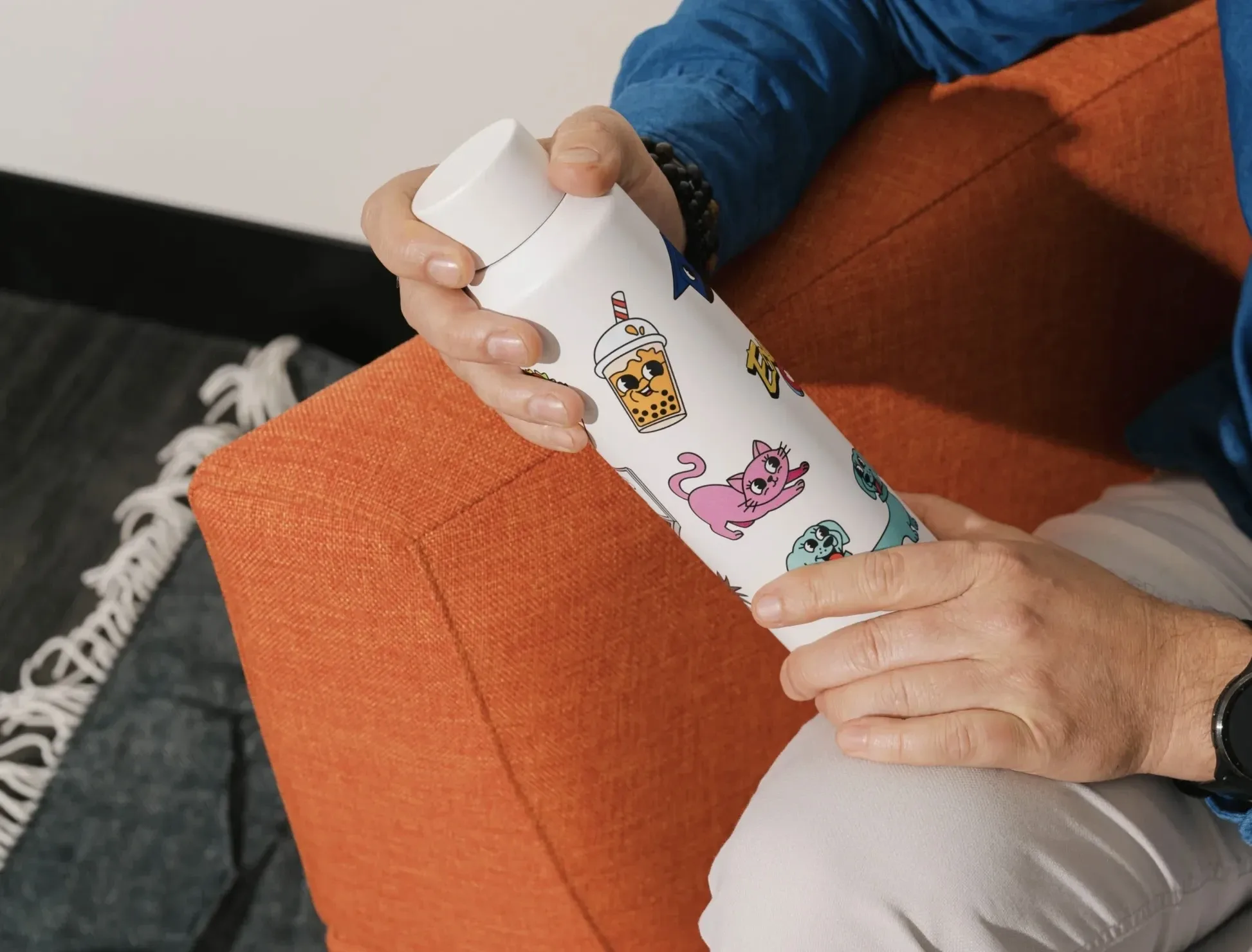 White water bottle with cartoon boba tea, cats, and dogs printed on it.