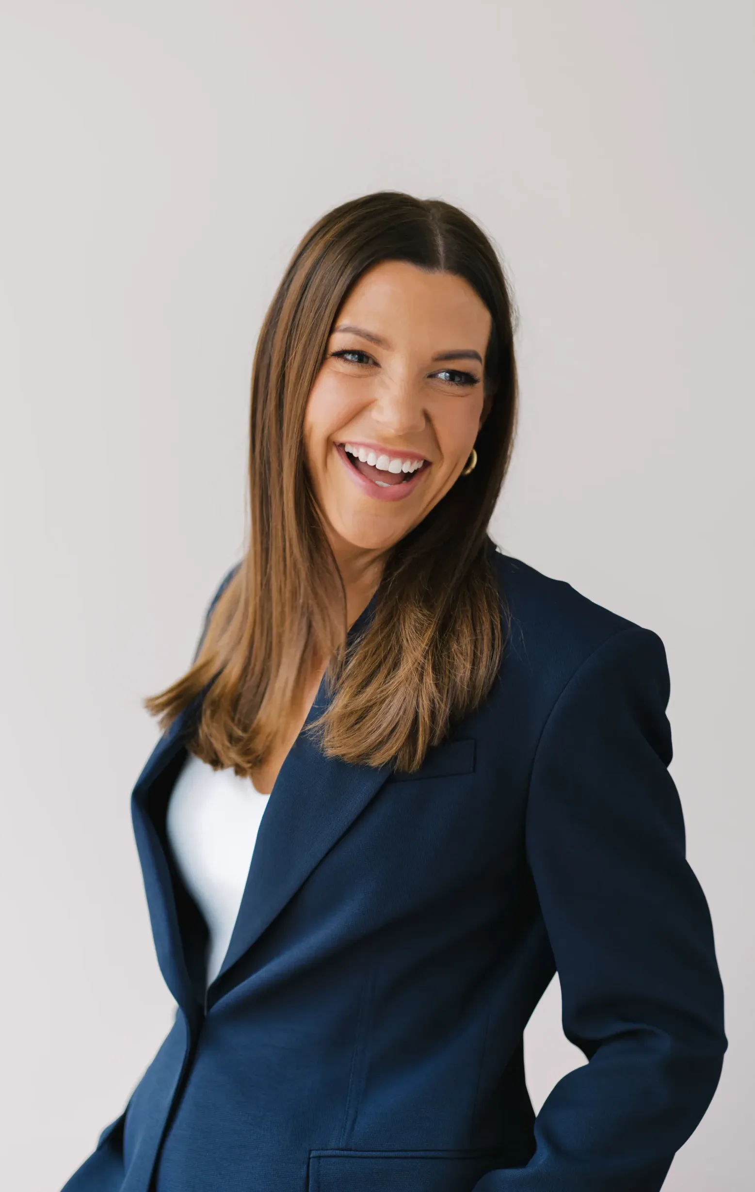 Sarah Muerkl smiles broadly while wearing a dark blue blazer over a white top.