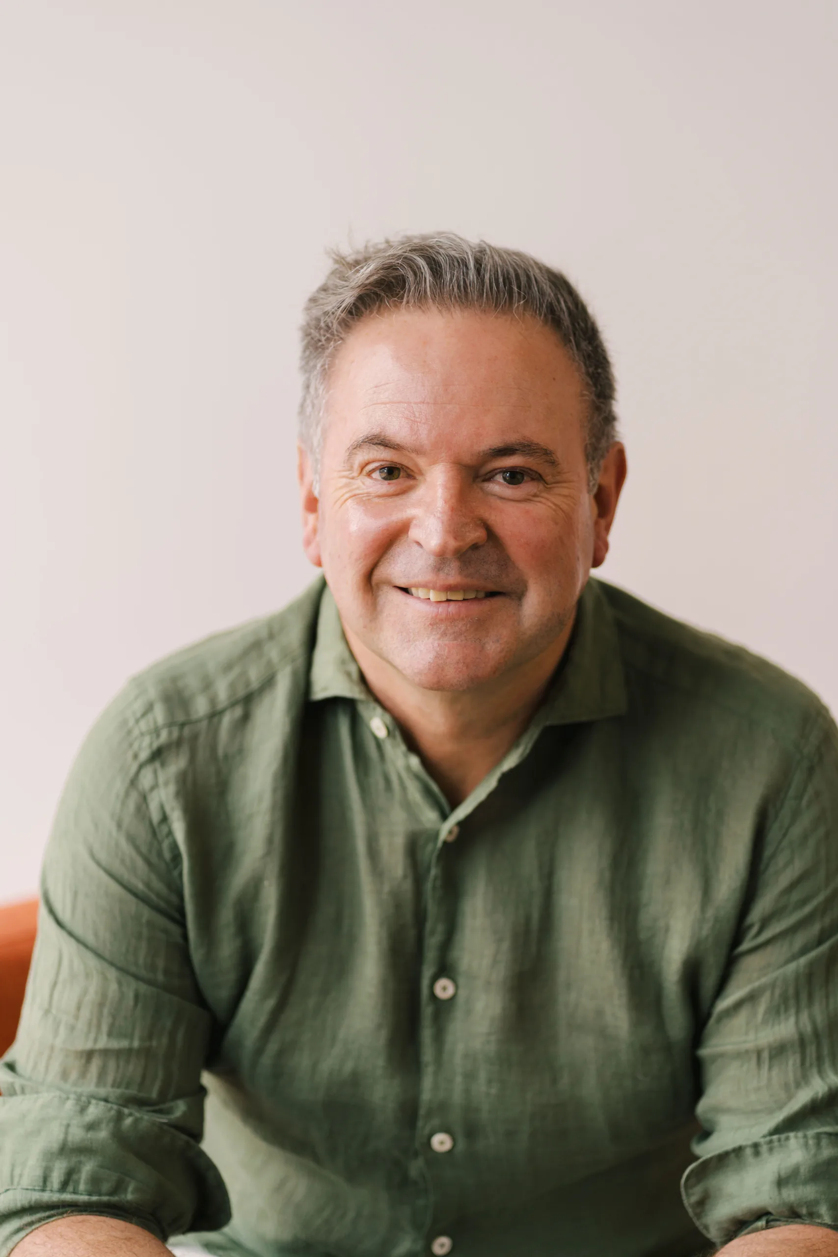 Nathan Schipper smiles wearing a green collared shirt.